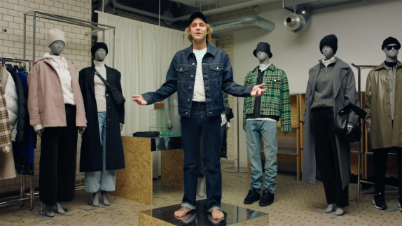 Person wearing denim surrounded by mannequins